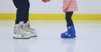 Adult skates on ice with child skates
