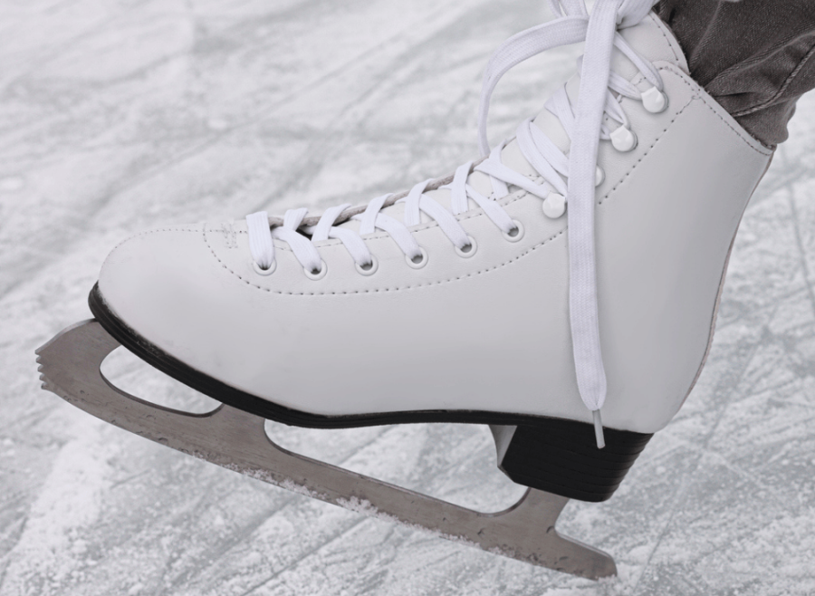 Woman's skate being tied up on rink