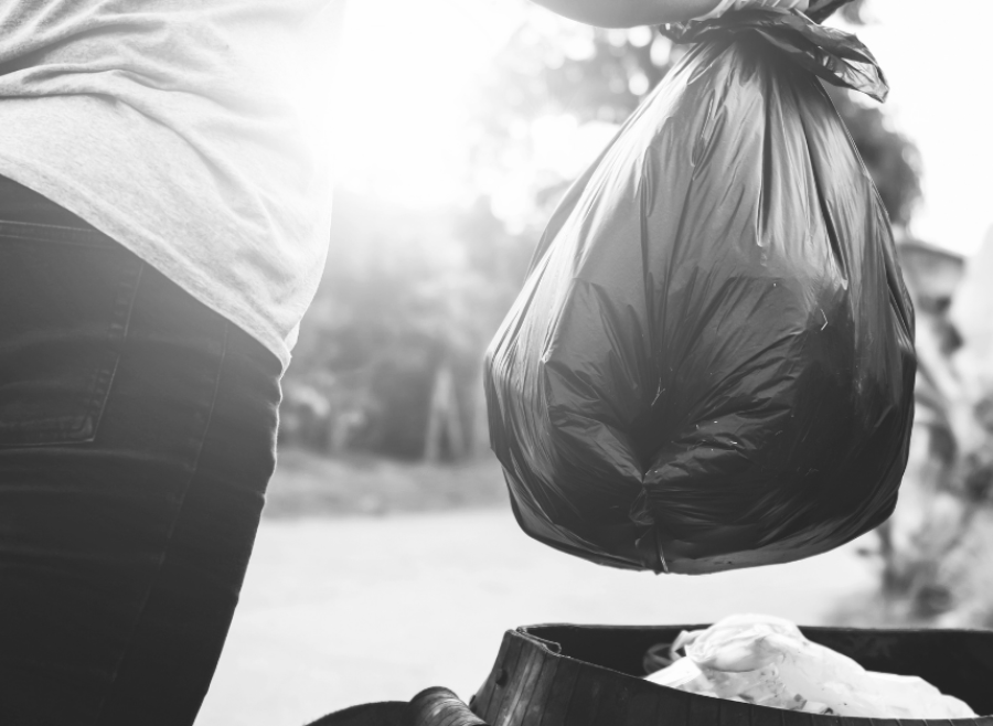 garbage bag held by woman in black and white