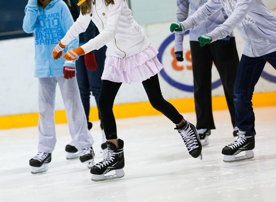 Kids skates on indoor arena ice pad.