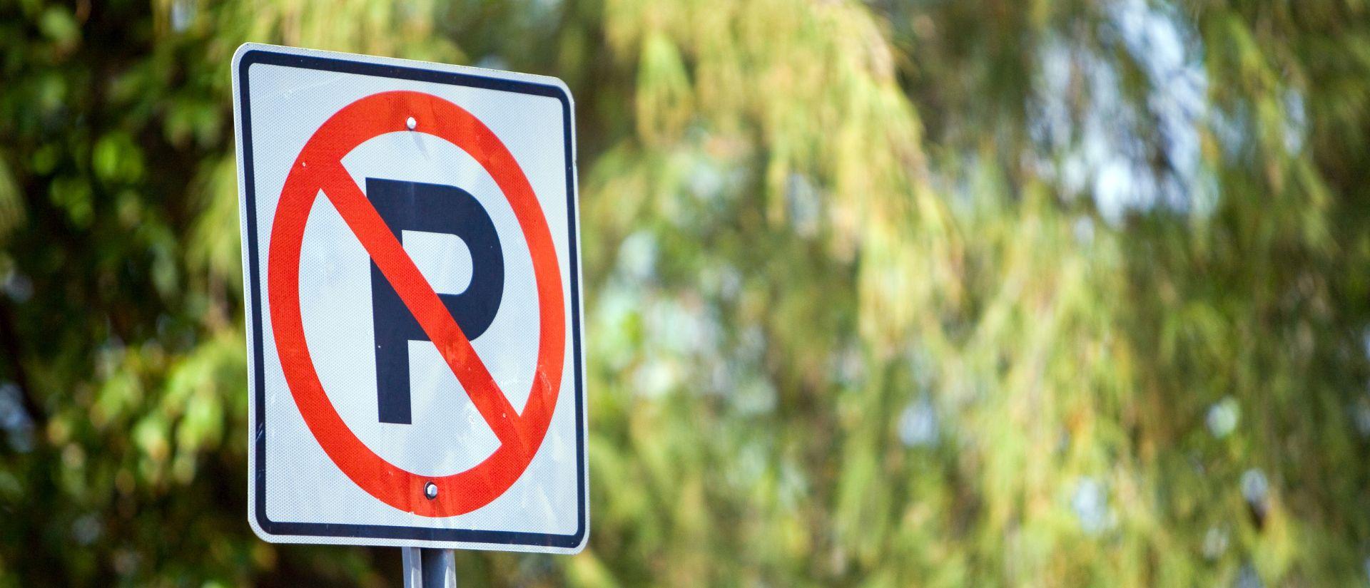 A prohibited parking sign in a wooded area