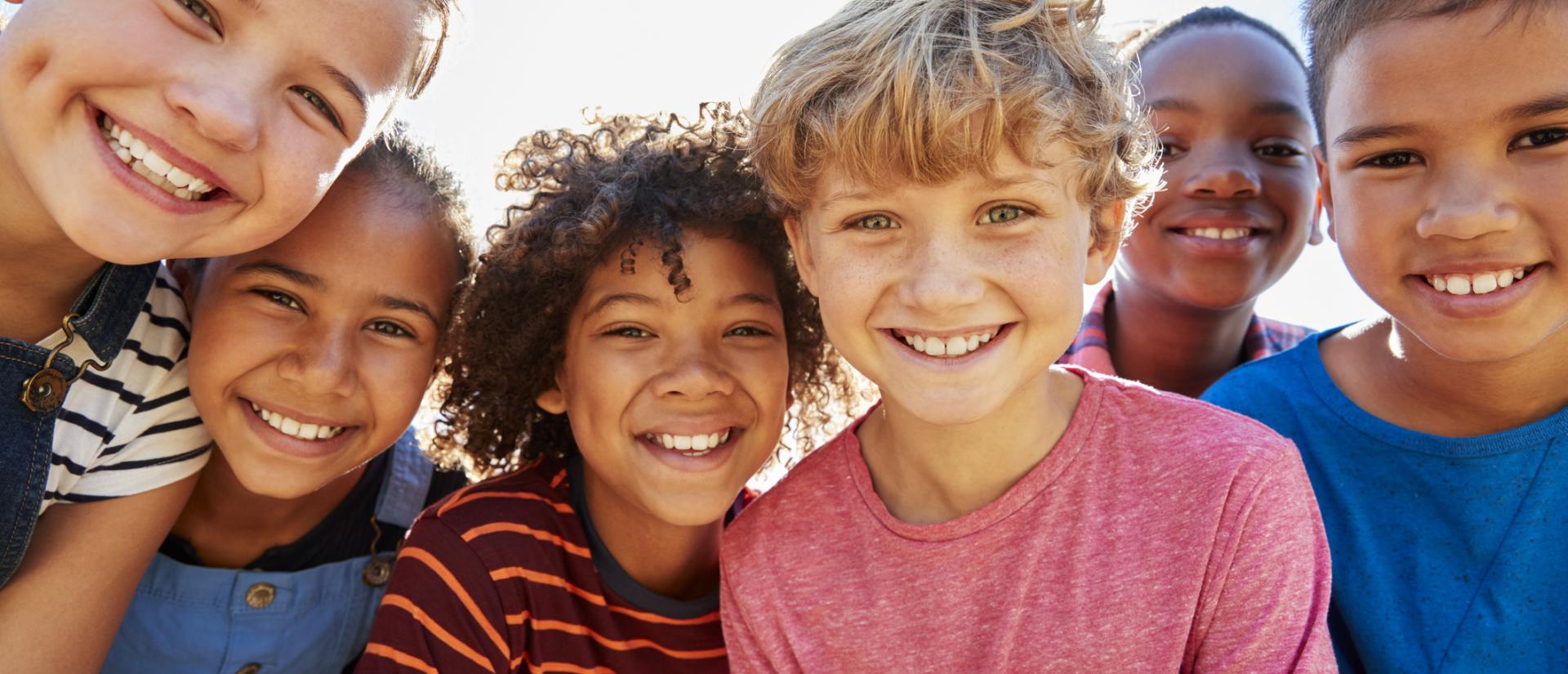 Girls and boys smiling outside