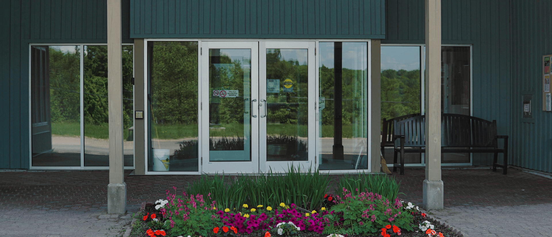 Entryway to a hall with a flower bed in front