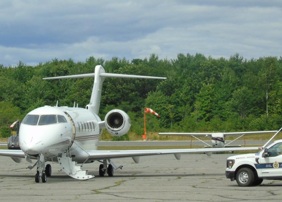Passenger airplane parked with the stairs descended and a pickup truck nearby